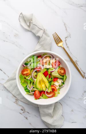 Salade verte saine avec avocat, tomates, mozzarella et oignons rouges Banque D'Images