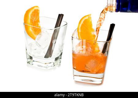 barman versant spritz apéritif cocktail aperol dans deux verres avec des tranches d'orange et des glaçons isolés sur fond blanc Banque D'Images