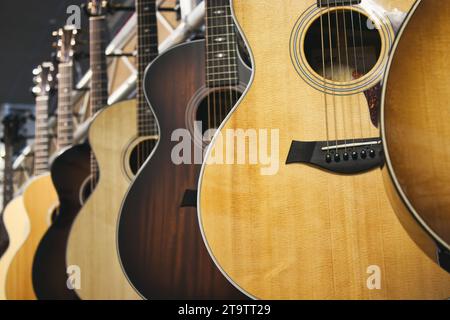 Une collection de guitares acoustiques de marque Taylor accrochées dans une rangée Banque D'Images