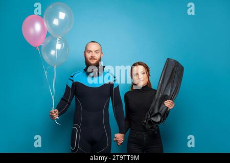 Homme et femme plongeur avec ballon rose sur fond bleu Banque D'Images