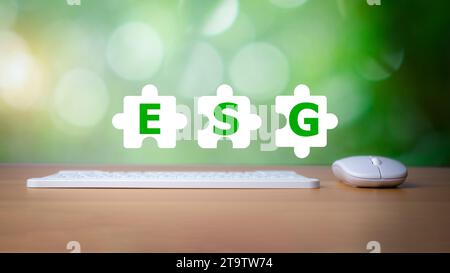 Clavier et souris placés sur un fond en bois avec des lettres imprimées sur une icône blanche Jigsaw représentant les concepts ESG pour l'environnement, social et g. Banque D'Images