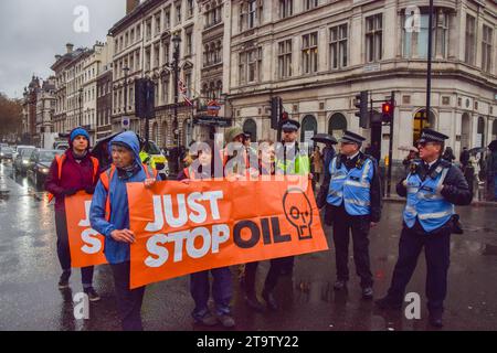 Londres, Royaume-Uni. 27 novembre 2023. Il suffit d'arrêter les activistes du pétrole marchent sur la place du Parlement. Le groupe d'action pour le climat a marché de Trafalgar Square sur le trottoir et a été arrêté quelques secondes après avoir marché sur la route une fois de plus alors qu'ils poursuivaient leurs protestations contre les nouvelles licences de combustibles fossiles. Crédit : Vuk Valcic/Alamy Live News Banque D'Images