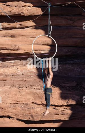 Un jeune homme se produit sur une lyra ou un cerceau aérien à 500 mètres au-dessus du fond du canyon lors d'un festival highline dans l'Utah. Banque D'Images