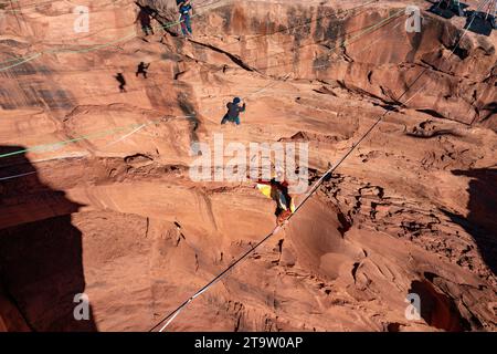 Vue aérienne d'une personne en costume de dinde surmontant 500 pieds au-dessus du fond du canyon au GGBY Highline Festival près de Moab, Utah. Banque D'Images