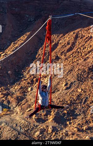 Une participante au GGBY World Highline Festival se produit sur les soies suspendues à une Highline. Moab, Utah. Le fond du canyon est de 500 pieds b Banque D'Images