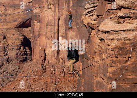 Deux hommes sur les Highlines au GGBY World Highline Festival 500 pieds au-dessus de Mineral Canyon près de Moab, Utah. Banque D'Images