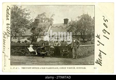 Carte postale édouardienne originale de la poste et Parsonage, Coney Weston, Suffolk, une pose familiale respectable devant la porte d'entrée, un enfant pousse un landau, peut-être le maître de poste ou la maîtresse de poste. Une scène typique du début des années 1900 dans l'Angleterre rurale. Carte postale datée du 7 mai 1905 sur le devant. Suffolk, Angleterre, Royaume-Uni Banque D'Images