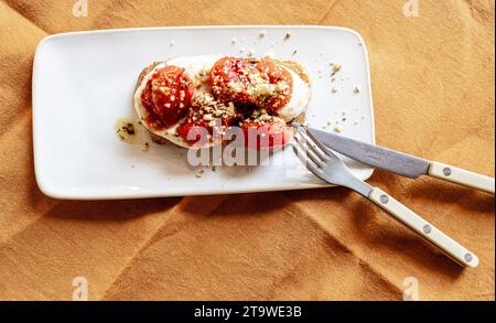 Gros plan de pain de blé entier grillé avec du fromage et des tomates rôties pour un petit déjeuner sain Banque D'Images
