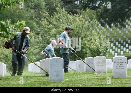 Washington, DC - 01 juin 2018 : les travailleurs tondent une herbe sur le cimetière national d'Arlington. Banque D'Images