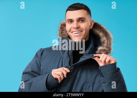 Jeune homme dans une veste bouffante élégante sur fond bleu Banque D'Images