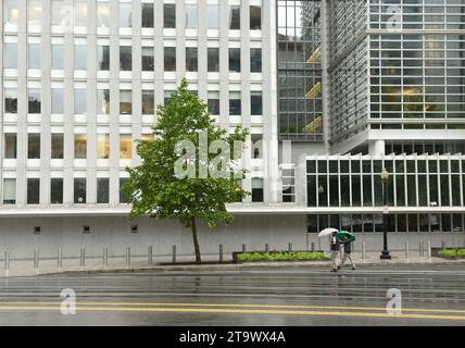 Washington, DC - 04 juin 2018 : piétons avec un parapluie près du bâtiment principal de la Banque mondiale à Washington. Banque D'Images