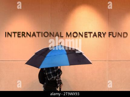 Washington, DC - 04 juin 2018 : piéton avec un parapluie près du Fonds monétaire international, siège du FMI 2 Building (HQ2) à DC. Banque D'Images