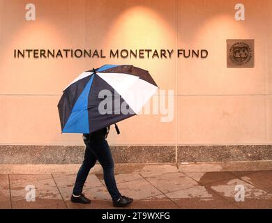 Washington, DC - 04 juin 2018 : piéton avec un parapluie près du Fonds monétaire international, siège du FMI 2 Building (HQ2) à DC. Banque D'Images