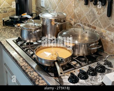 Casseroles et poêles cuisant sur une cuisinière à gaz dans une maison résidentielle familiale ou une maison. Banque D'Images