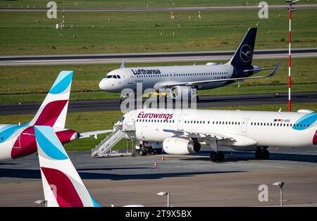 Aéroport de Düsseldorf, Lufthansa Airbus A320-200 sur la voie de circulation, Eurowings Airbus A319-100 en position parking Banque D'Images