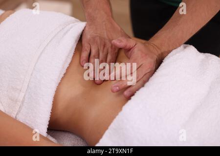 Femme recevant un massage professionnel du ventre à l'intérieur, closeup Banque D'Images