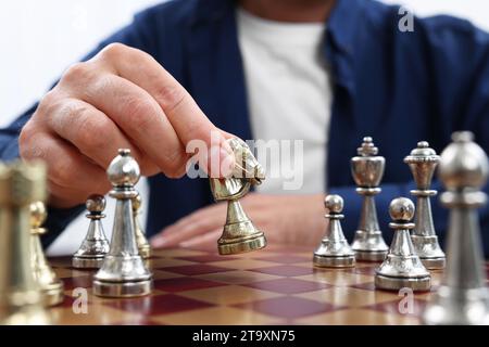 Homme déplaçant chevalier sur l'échiquier, vue rapprochée Banque D'Images