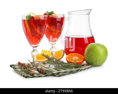 Cocktail de Noël sangria dans des verres et une cruche, ingrédients et branche de sapin isolé sur blanc Banque D'Images