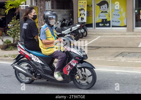 SAMUT PRAKAN, THAÏLANDE, septembre 30 2023, chauffeur de taxi en moto avec une femme. Banque D'Images