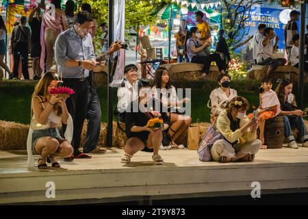 Bangkok, Thaïlande. 27 novembre 2023. Les thaïlandais et les étrangers sont vus avec leur krathong, sur la rive du lac, pendant le festival magique de Loy Krathong, à Jodd Fairs Dan Neramit, à Bangkok. Loy Krathong 'To Float rituel vaisseau or lamp' est un festival thaïlandais célébré chaque année dans toute la Thaïlande†et dans les pays voisins, où dans la nuit de la pleine lune, les Krathongs qui sont décorées avec des feuilles de bananier richement pliées, trois bâtons d'encens, et une bougie, sont lancés par les thaïlandais, sur une rivière, un canal, ou un étang, faisant un vœu comme ils le font. Crédit : SOPA Images Limited/Alamy Live News Banque D'Images