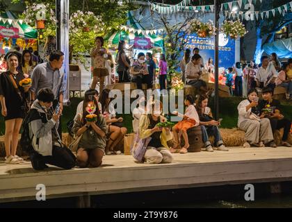 Des thaïlandais et des étrangers sont vus prier devant leur krathong avant de le mettre sur le lac, pendant le festival magique de Loy Krathong, à Jodd Fairs Danneramit, à Bangkok. Loy Krathong 'To Float rituel vaisseau or lamp' est un festival thaïlandais célébré chaque année dans toute la Thaïlande†et dans les pays voisins, où dans la nuit de la pleine lune, les Krathongs qui sont décorées avec des feuilles de bananier richement pliées, trois bâtons d'encens, et une bougie, sont lancés par les thaïlandais, sur une rivière, un canal, ou un étang, faisant un vœu comme ils le font. Banque D'Images