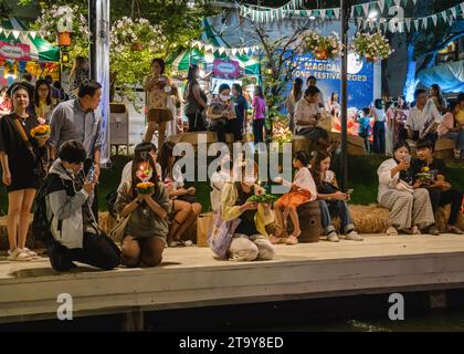 Des thaïlandais et des étrangers sont vus prier devant leur krathong avant de le mettre sur le lac, pendant le festival magique de Loy Krathong, à Jodd Fairs Danneramit, à Bangkok. Loy Krathong 'To Float rituel vaisseau or lamp' est un festival thaïlandais célébré chaque année dans toute la Thaïlande†et dans les pays voisins, où dans la nuit de la pleine lune, les Krathongs qui sont décorées avec des feuilles de bananier richement pliées, trois bâtons d'encens, et une bougie, sont lancés par les thaïlandais, sur une rivière, un canal, ou un étang, faisant un vœu comme ils le font. (Photo Nathalie Jamois/SOPA Images/Sipa USA) Banque D'Images