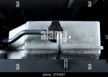 Bouteille de radiateur d'eau de refroidissement de voiture dans le compartiment moteur. Concept d'entretien de voiture. Banque D'Images