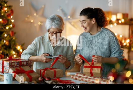 Joyeux Noël et joyeuses fêtes. Jolies femmes gaies préparant des cadeaux. Banque D'Images