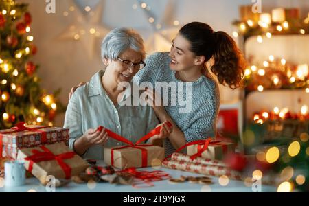 Joyeux Noël et joyeuses fêtes. Jolies femmes gaies préparant des cadeaux. Banque D'Images