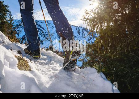 Gros plan des jambes d'un trekking touristique haut dans les montagnes. Hiver journée ensoleillée en plein air dans les montagnes Banque D'Images