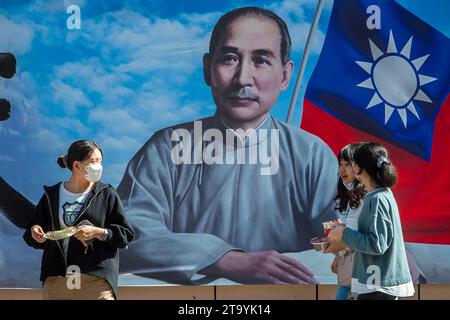 Les passants marchent devant une image de Sun Yat-sen - politicien chinois et révolutionnaire, leader et fondateur du Kuomintang, considéré comme le fondateur de la Chine moderne et démocratique dans le centre-ville de Taipei, Taïwan le 28/11/2023 les résultats d'une enquête récente révèlent une majorité croissante de Taïwanais favorables au maintien permanent du statu quo actuel traversant le détroit, selon un sondage réalisé par le World United Formosans for Independence et l'Association de sécurité nationale de Taïwan. Les données montrent une légère hausse de ce sentiment par rapport aux années précédentes, plus de 44 % des participants préférant cette option. Meanw Banque D'Images