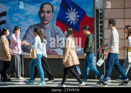 Les passants marchent devant une image de Sun Yat-sen - politicien chinois et révolutionnaire, leader et fondateur du Kuomintang, considéré comme le fondateur de la Chine moderne et démocratique dans le centre-ville de Taipei, Taïwan le 28/11/2023 les résultats d'une enquête récente révèlent une majorité croissante de Taïwanais favorables au maintien permanent du statu quo actuel traversant le détroit, selon un sondage réalisé par le World United Formosans for Independence et l'Association de sécurité nationale de Taïwan. Les données montrent une légère hausse de ce sentiment par rapport aux années précédentes, plus de 44 % des participants préférant cette option. Meanw Banque D'Images