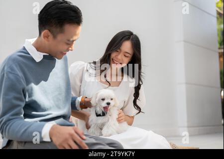 Jeune couple asiatique avec mignon petit chien, passer du temps en famille ensemble. Concept de couple. Banque D'Images