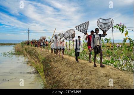 Non exclusive : 28 novembre 2023 Sylhet-Bangladesh : les populations rurales armées de pièges à poissons en bambou et filet prennent part à la célébration dans un hiver de 200 ans f Banque D'Images