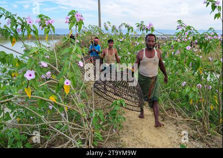 Non exclusive : 28 novembre 2023 Sylhet-Bangladesh : les populations rurales armées de pièges à poissons en bambou et filet prennent part à la célébration dans un hiver de 200 ans f Banque D'Images