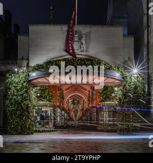 Un sentier lumineux passe devant la façade de Burlington Arcade qui est illuminée de décorations de noël la nuit à Londres. Banque D'Images