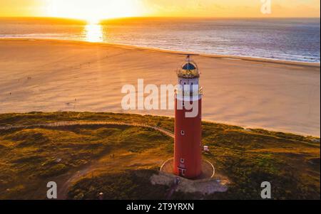 Phare de Texell au coucher du soleil pays-Bas Île néerlandaise Texel en été avec des dunes de sable à l'île des Wadden. drone vue aérienne d'en haut pendant le coucher du soleil à la plage avec un coucher de soleil dans l'océan Banque D'Images