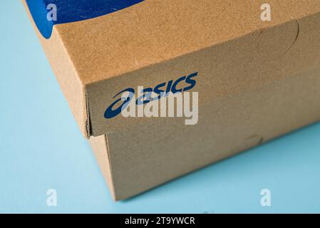 Antalya, Turquie - 28 novembre 2023 : boîte à chaussures de sport avec logo Asics imprimé. sur fond bleu Banque D'Images