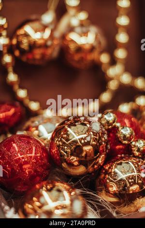 Composition festive de Noël de boules de nouvel an or brillant et rouge et perles brillantes. Arrière-plan vertical Banque D'Images