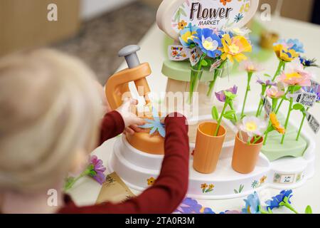 28 novembre 2023, Bavière, Nuremberg : Franziska, 5 ans, joue avec le «marché aux fleurs» de Smoby Toys lors de la conférence de presse annuelle de l'Association allemande de vente au détail de jouets (BVS) et de l'Association allemande de l'industrie du jouet (DVSI). Le jouet, qui permet aux enfants de créer leurs propres fleurs, est l'un des 'Top 10 Toys 2023' publié par le BVS. Le DVSI et le BVS donnent un aperçu des importantes affaires de Noël et des chiffres actuels pour les derniers mois. Photo : Daniel Karmann/dpa Banque D'Images