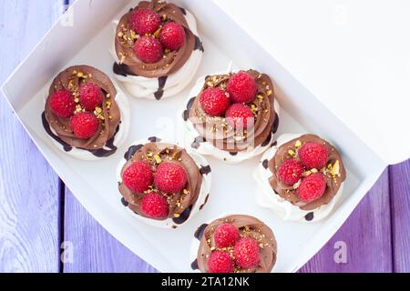 Mini gâteaux à la crème fouettée, chocolat, meringue et framboises fraîches. Affiche de confiserie pour café ou restaurant Banque D'Images