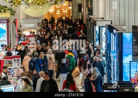 Des hordes de consommateurs envahissent le magasin phare Macy's Herald Square à New York désireux de magasiner le lendemain de Thanksgiving, le Black Friday, le 24 novembre 2023 la National Retail Federation prévoit que 182 millions de personnes feront leurs achats au cours du week-end du Black Friday, en personne et en ligne, culminant avec le Cyber Monday. (© Richard B. Levine) Banque D'Images