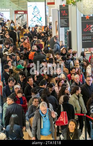 Des hordes de consommateurs envahissent le magasin phare Macy's Herald Square à New York désireux de magasiner le lendemain de Thanksgiving, le Black Friday, le 24 novembre 2023 la National Retail Federation prévoit que 182 millions de personnes feront leurs achats au cours du week-end du Black Friday, en personne et en ligne, culminant avec le Cyber Monday. (© Richard B. Levine) Banque D'Images