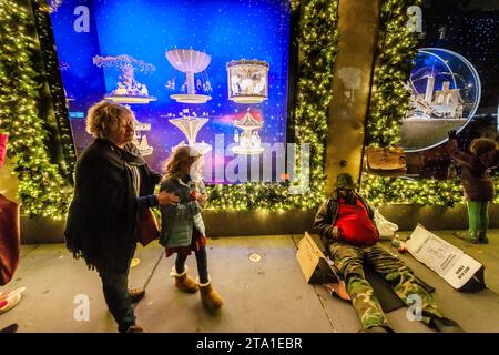 Un vétérinaire sans-abri campe devant Saks Fifth Avenue à New York et leur vitrine de Noël mondialement connue avec la collaboration de Saks avec Dior lors de leur spectacle de lumières, le mercredi 22 novembre 2023 (© Richard B. Levine) Banque D'Images