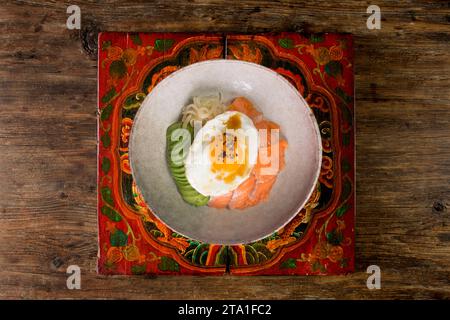 Donburi de saumon teriyaki avec œuf au plat, avocat, oignon, poivron rouge et autres légumes. Plat typiquement japonais. Banque D'Images