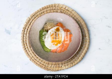 Donburi de saumon teriyaki avec œuf au plat, avocat, oignon, poivron rouge et autres légumes. Plat typiquement japonais. Banque D'Images