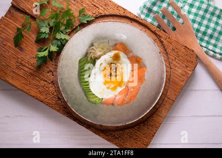 Donburi de saumon teriyaki avec œuf au plat, avocat, oignon, poivron rouge et autres légumes. Plat typiquement japonais. Banque D'Images