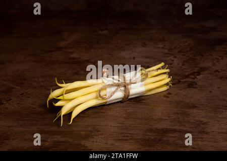 Bouquet de gousses jaunes crues de haricot sur fond de bois. Haricots français ou haricots verts également connus sous le nom de haricots String de l'Inde. Collecte de légumes. Banque D'Images