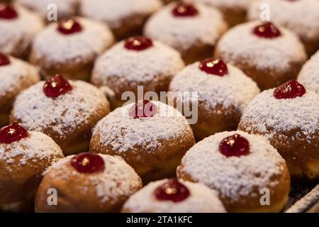 Beignets décoratifs dans une boulangerie de Jérusalem lors de la célébration de la fête juive de Hanoukka, quand il est traditionnel de manger des aliments frits dans l'huile. Banque D'Images