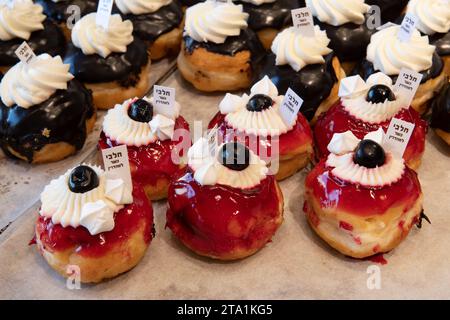 Beignets décoratifs dans une boulangerie de Jérusalem lors de la célébration de la fête juive de Hanoukka, quand il est traditionnel de manger des aliments frits dans l'huile. Banque D'Images